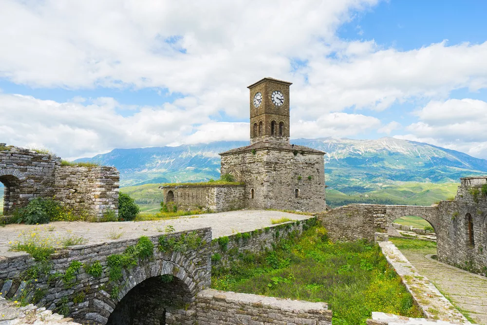 kleine klokkentoren met een berg op de achtergrond in Albanië