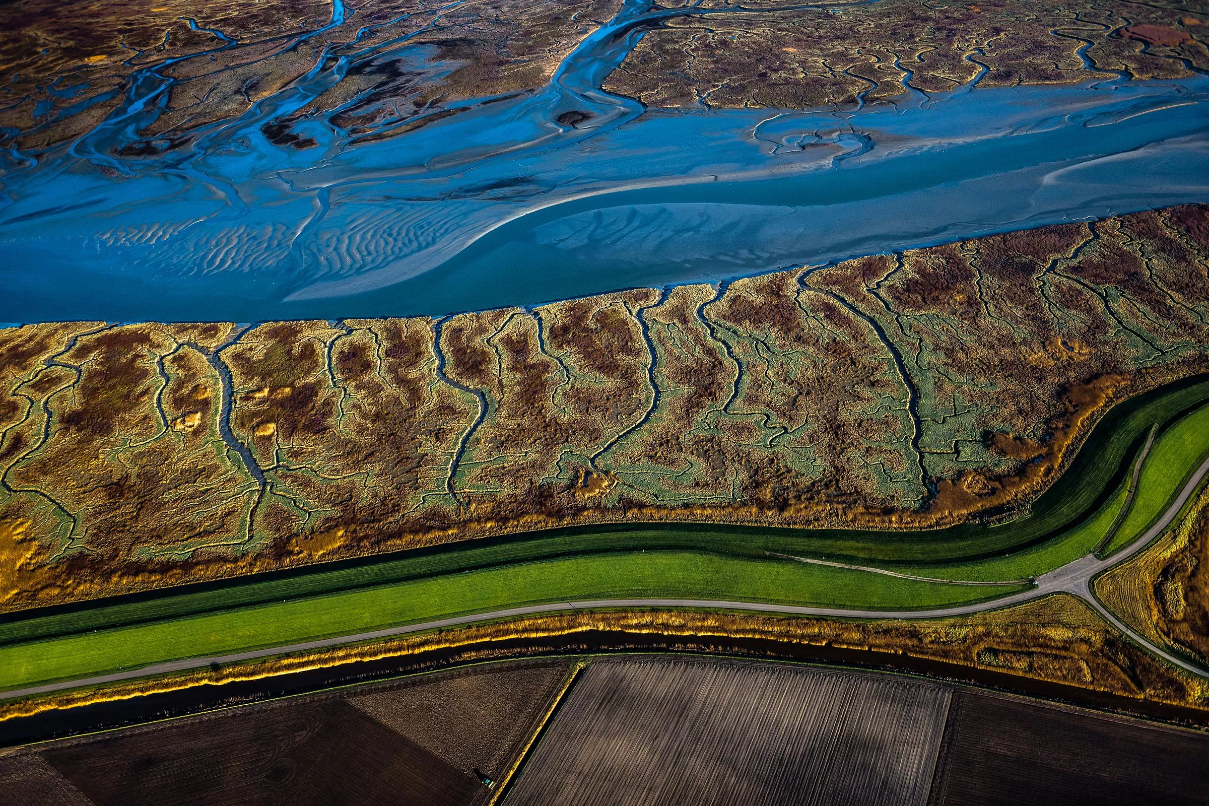 bovenaanzicht Saeftinghe, land onder water met duinen