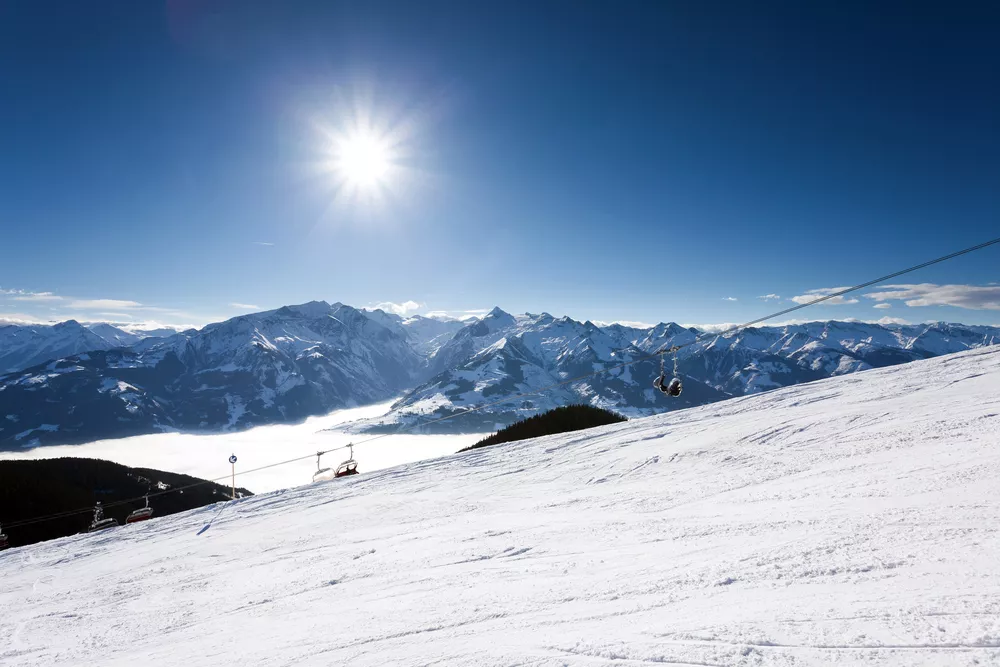 besneeuwde bergtoppen en een skipiste