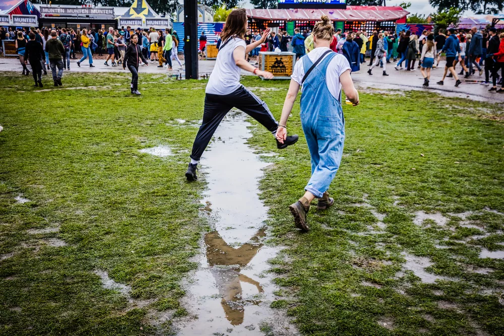 Bezoekers hebben plezier tijdens slecht weer op het Lowlands festival